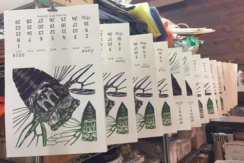 Screen printed June 2019 calendar pages hanging to dry.